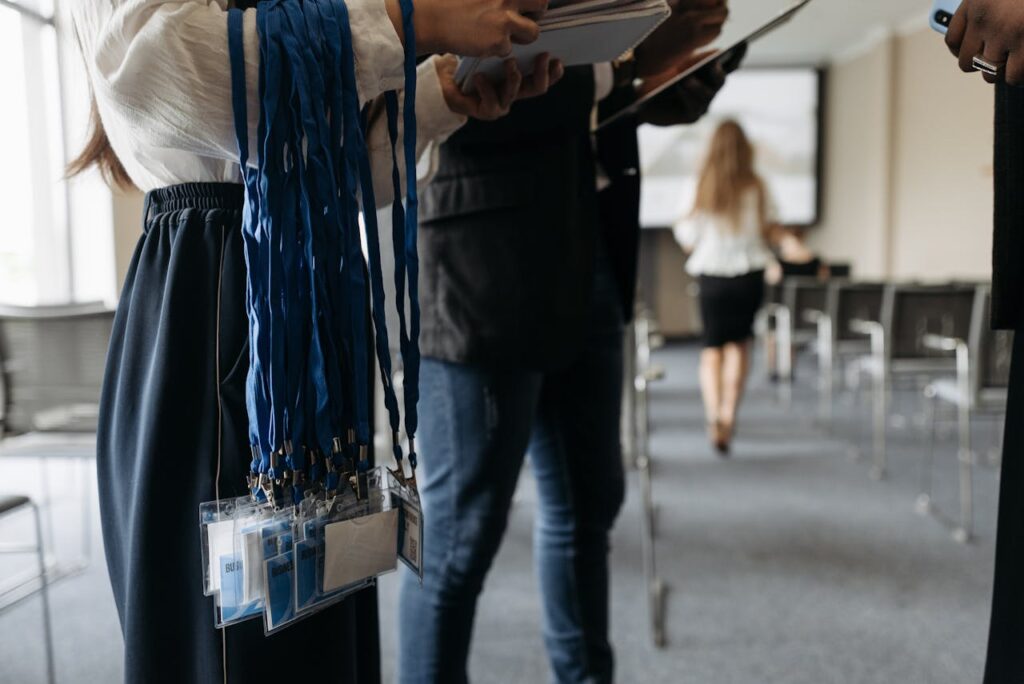People in a conference room preparing with lanyards and badges.